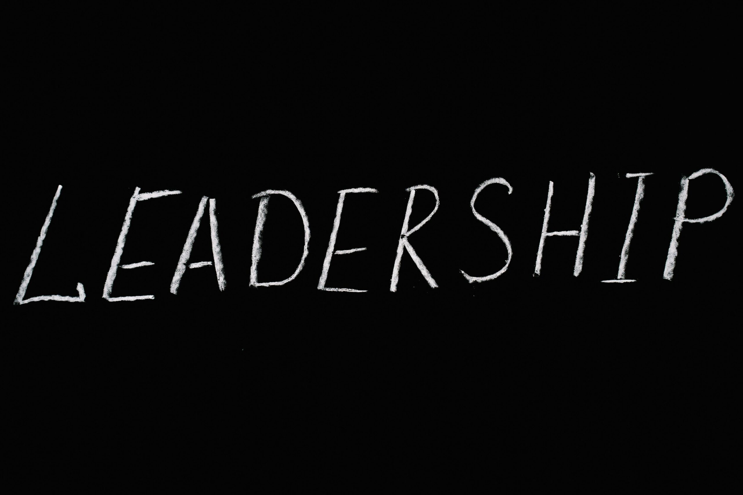 Chalk text spelling 'Leadership' on a blackboard, symbolizing guidance and authority.